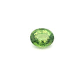 An oval-cut green sapphire with a faceted surface, centered on a plain white background.