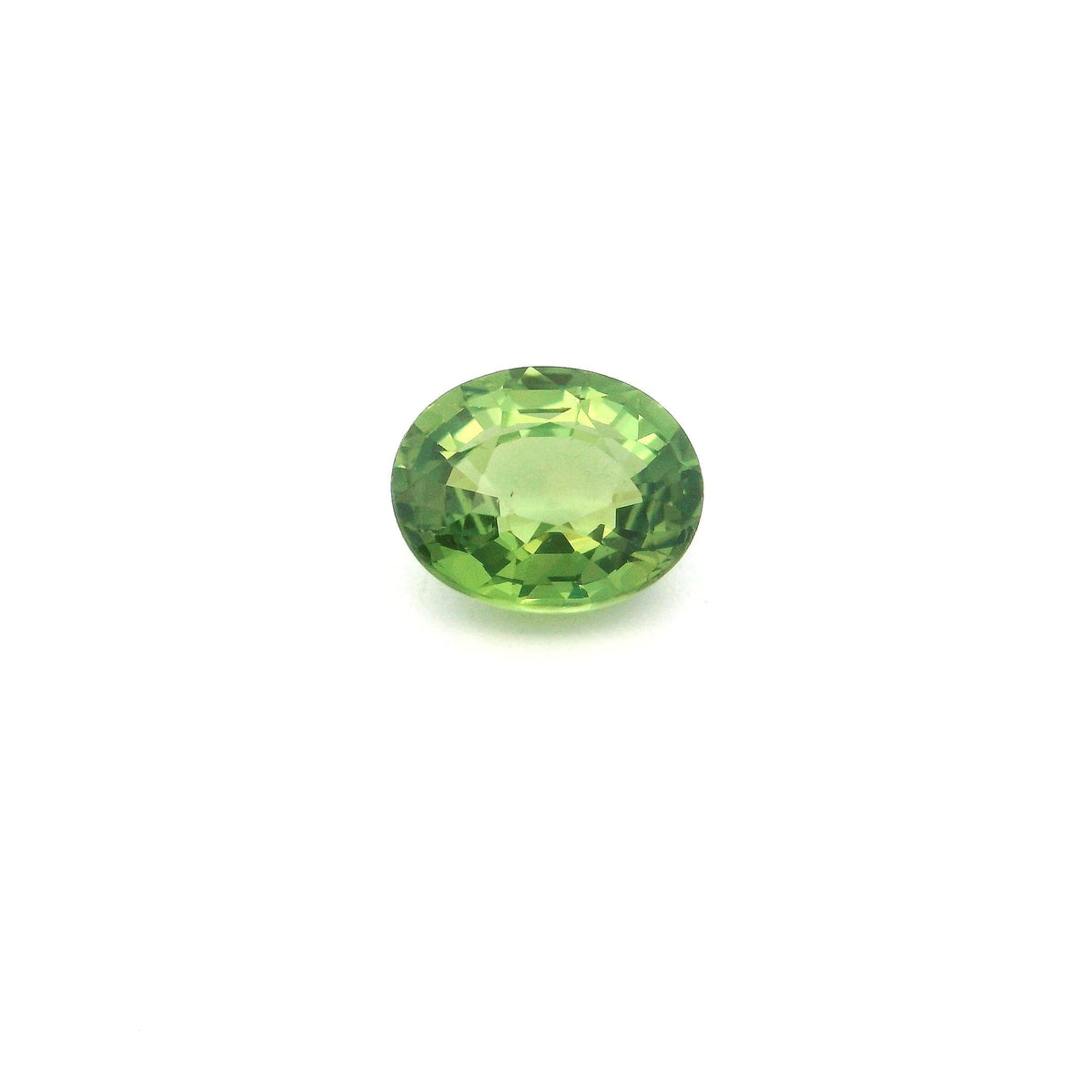 An oval-cut green sapphire with a faceted surface, centered on a plain white background.